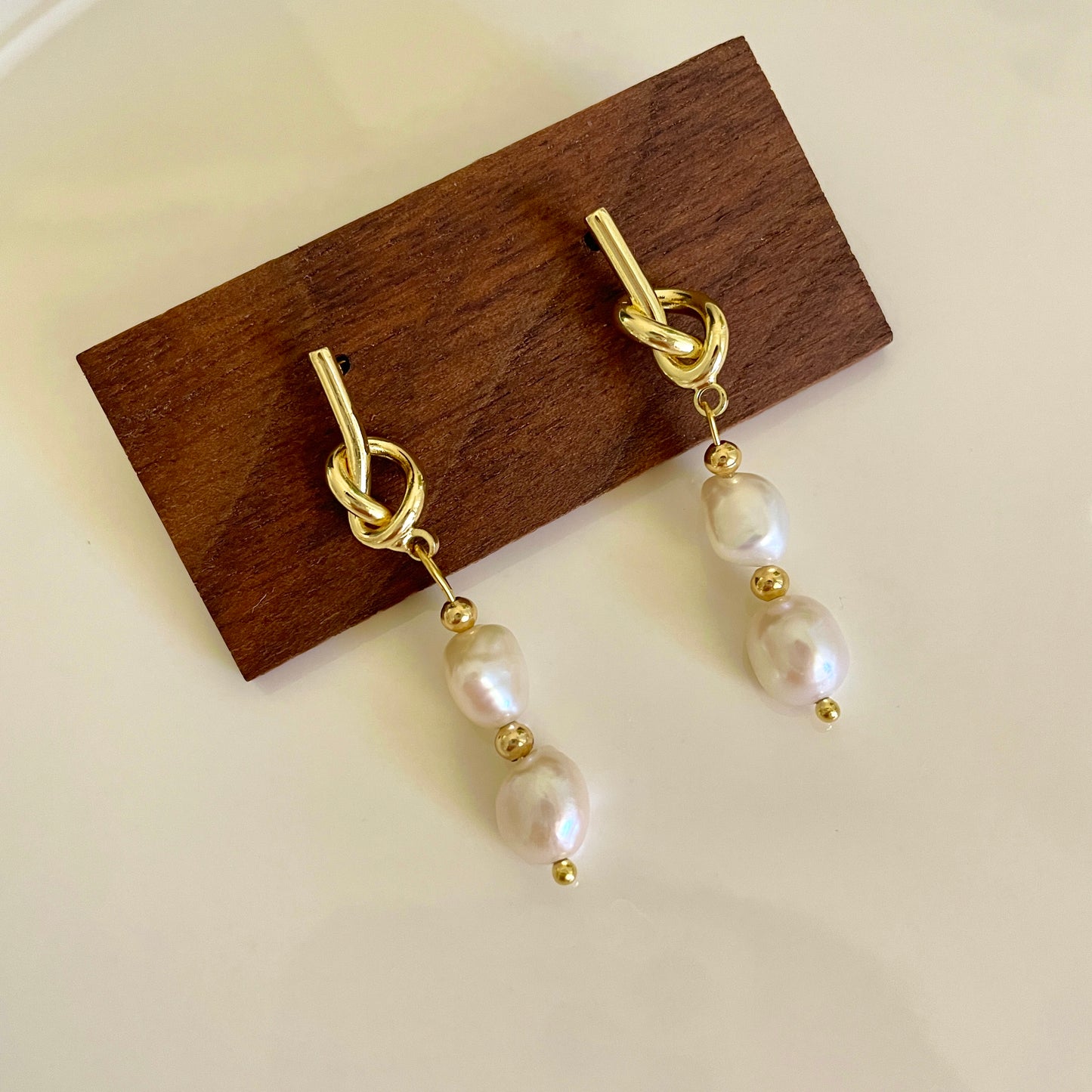 Earrings with knotted metal shape and two Baroque pearls hanging below