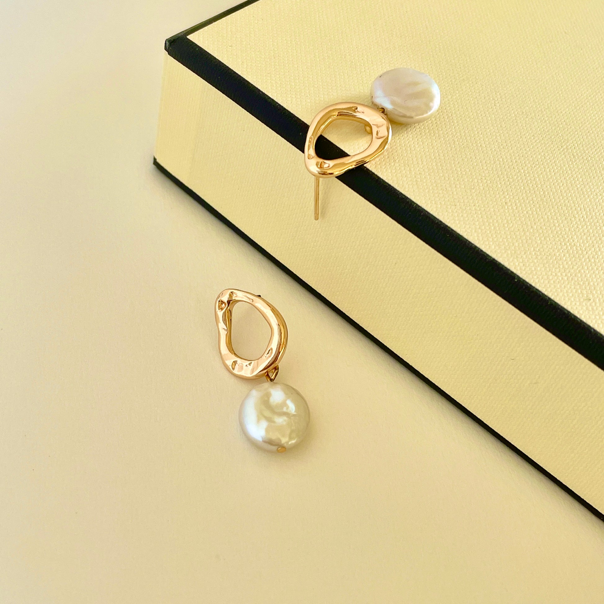 Pearl earring: A metal hoop with a button-like shape Baroque pearl