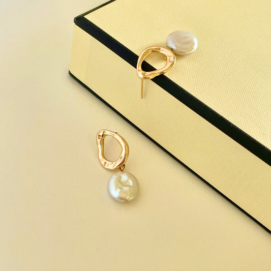 Pearl earring: A metal hoop with a button-like shape Baroque pearl