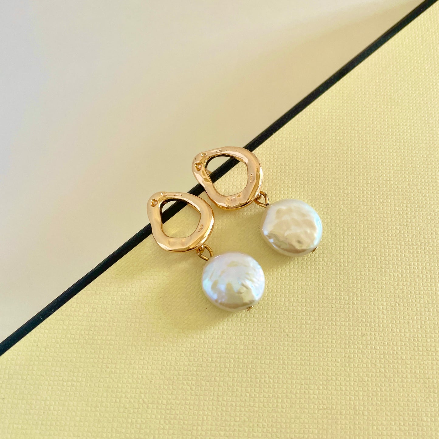 Pearl earring: A metal hoop with a button-like shape Baroque pearl